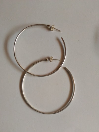 two silver earrings within custom made realization