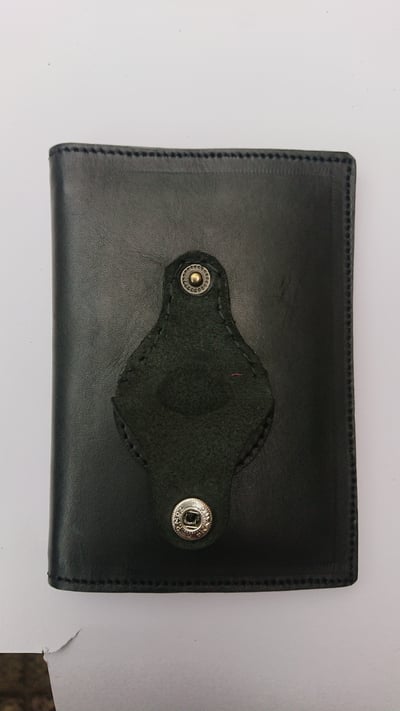 Personalisiertes Portemonnaie aus schwarzem Leder mit Tasche waehrend der Massanfertigung