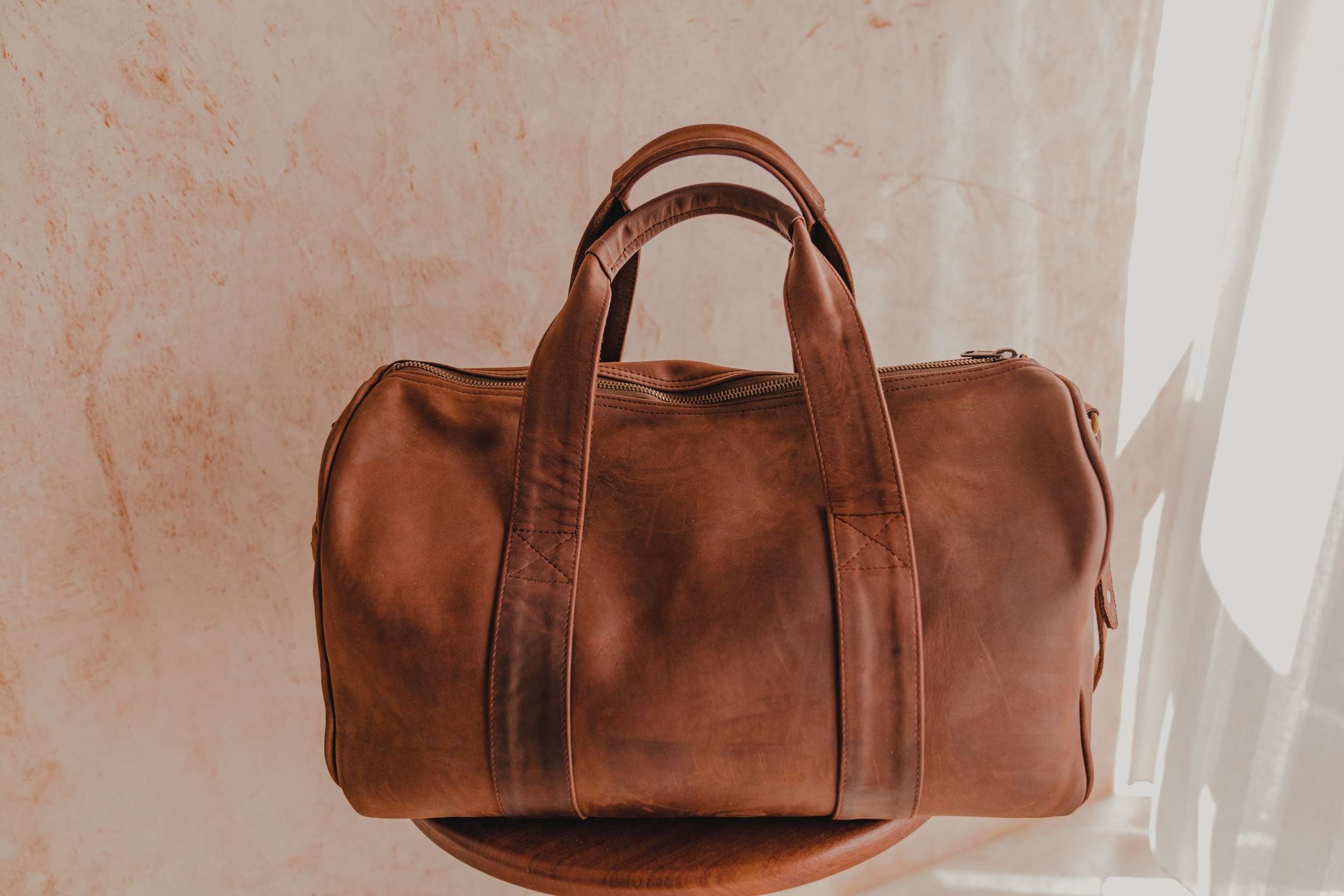 A custom made leather travel bag made by an Urban Change Lab artisan.