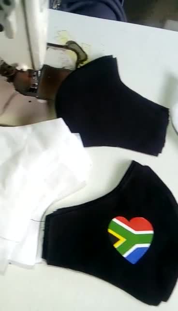 Maßgefertigte Mundschutzmasken mit der Flagge von Südafrika waehrend der Massanfertigung