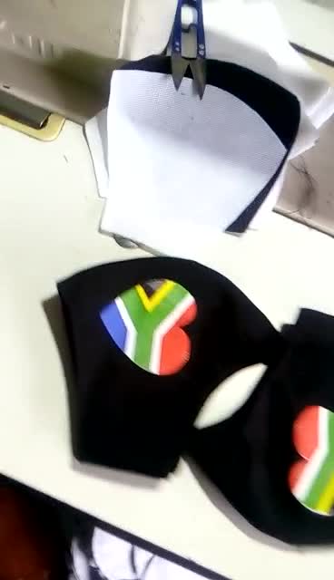 Maßgefertigte Mundschutzmasken mit der Flagge von Südafrika waehrend der Massanfertigung