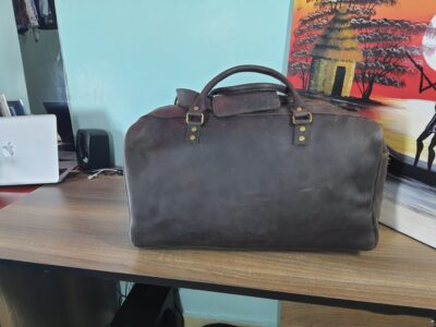 Custom made unisex duffle bag made from dark brown leather within custom made realization